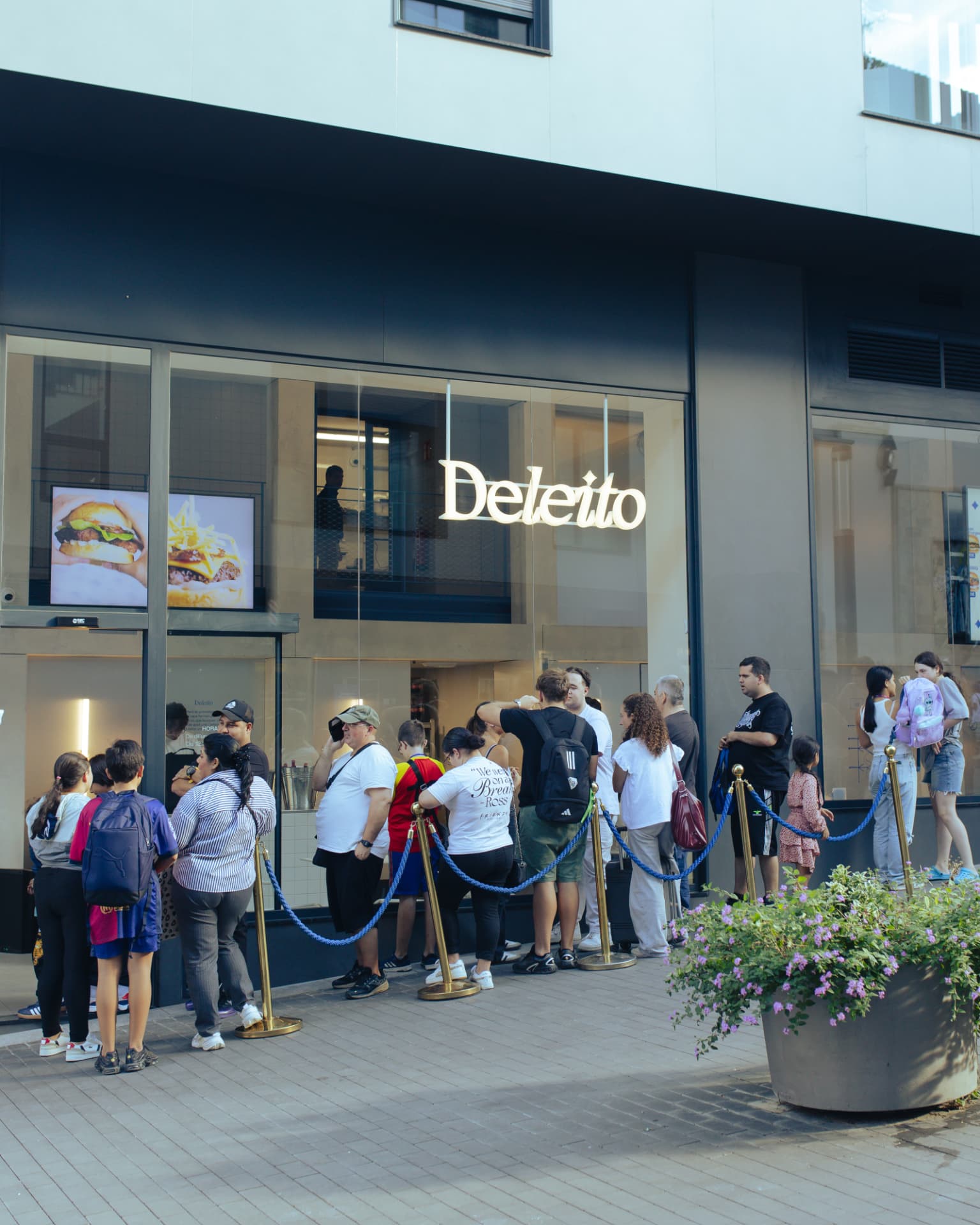 Fachada de un restaurante Deleito con cola de clientes